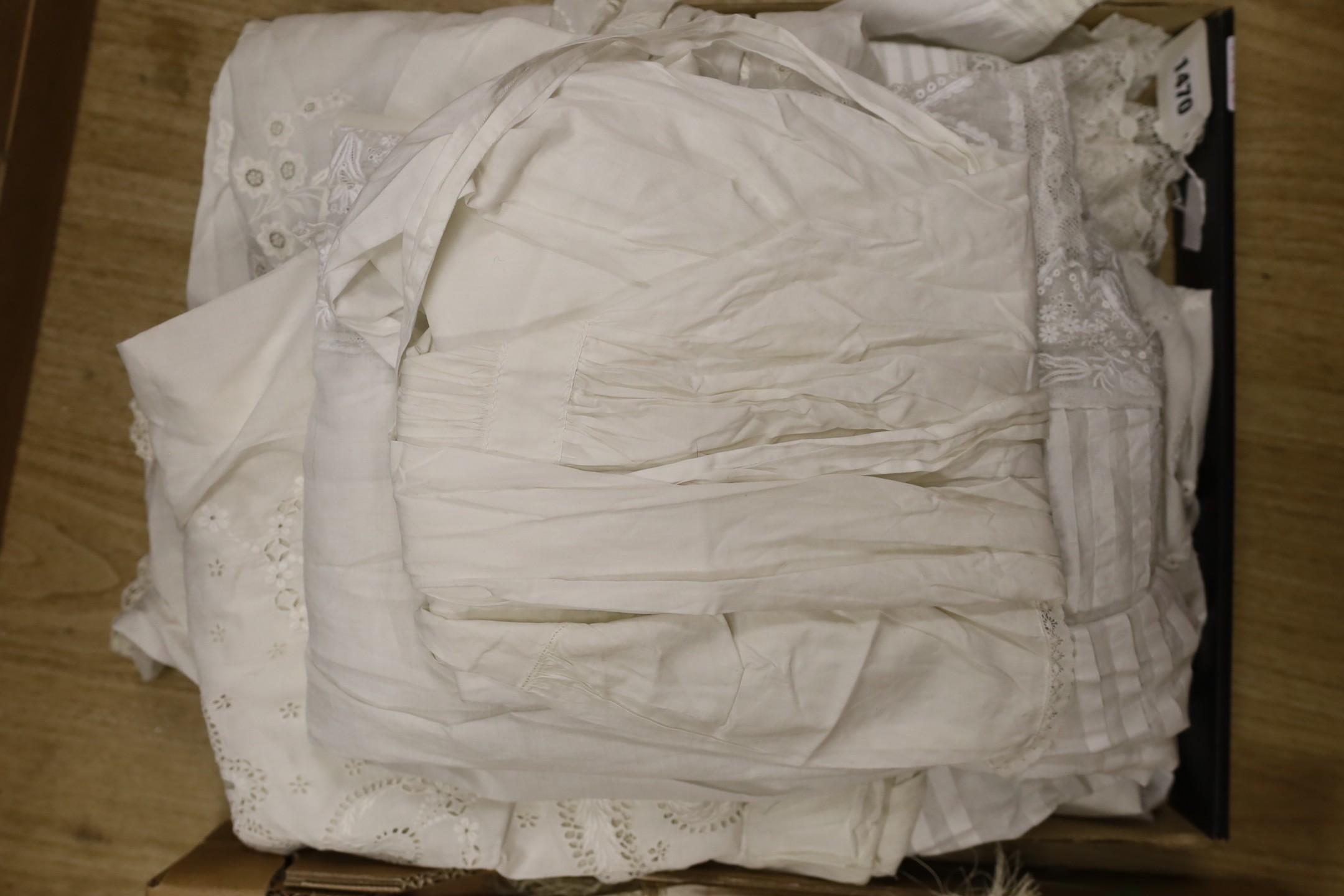 A collection of white worked christening gowns, a christening cape, a silk parasol, a lace bonnet veil and later shawl.